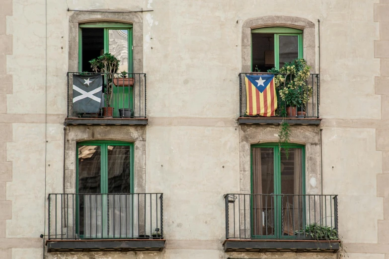 two windows with a balcony balconies and an american flag