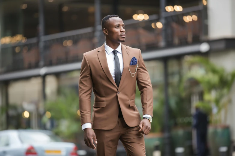 a man in brown suit walking down a street