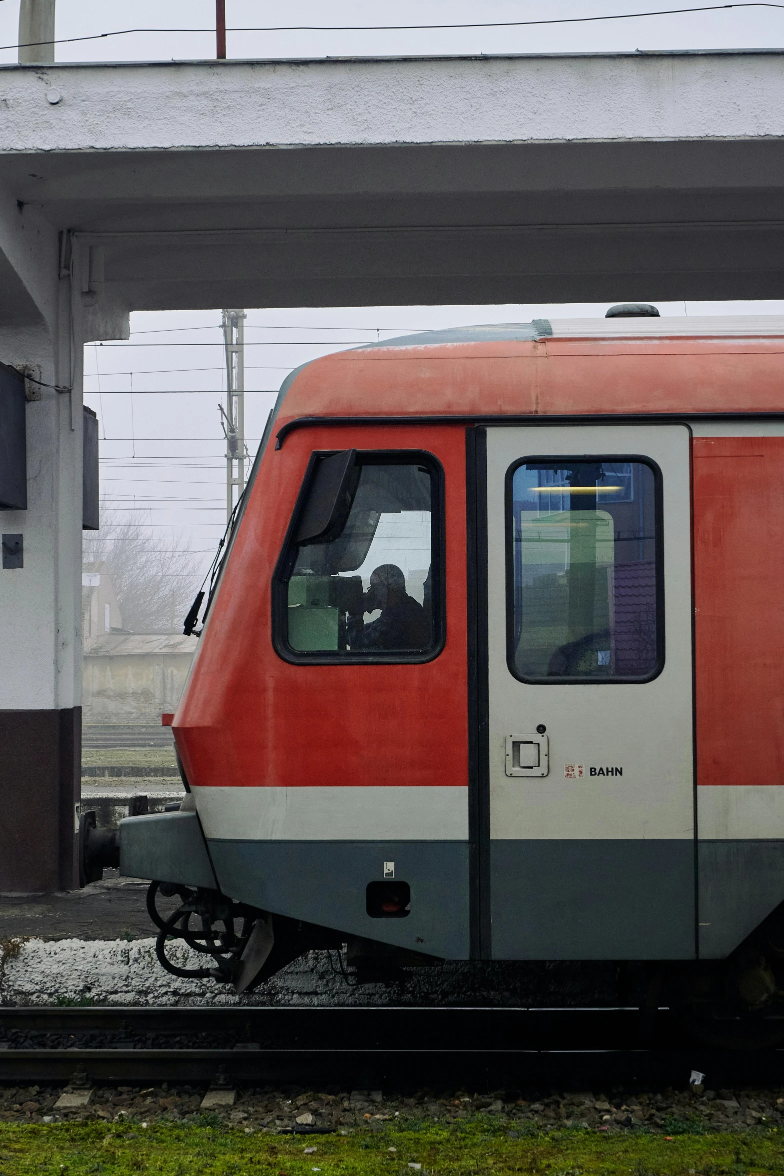 a red and gray train is stopped at the station