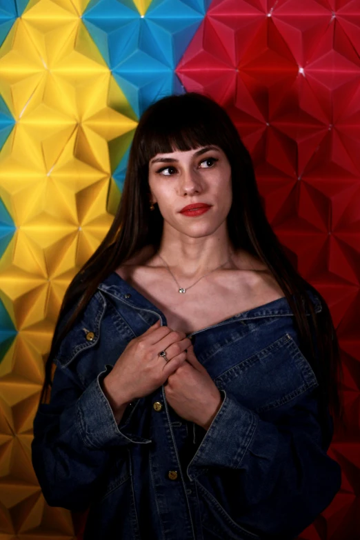 a woman with long hair standing in front of geometric art