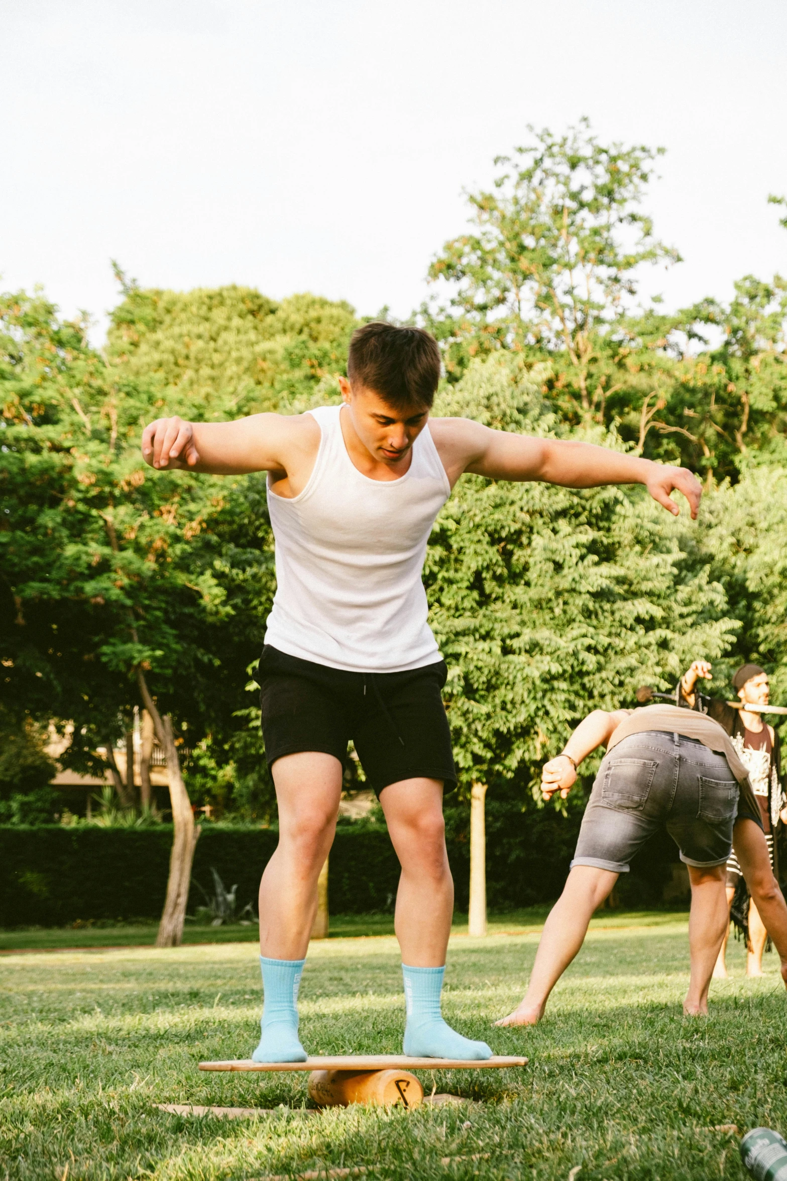 a man standing on top of a skateboard in the grass