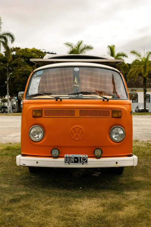 a orange van parked in a grassy field