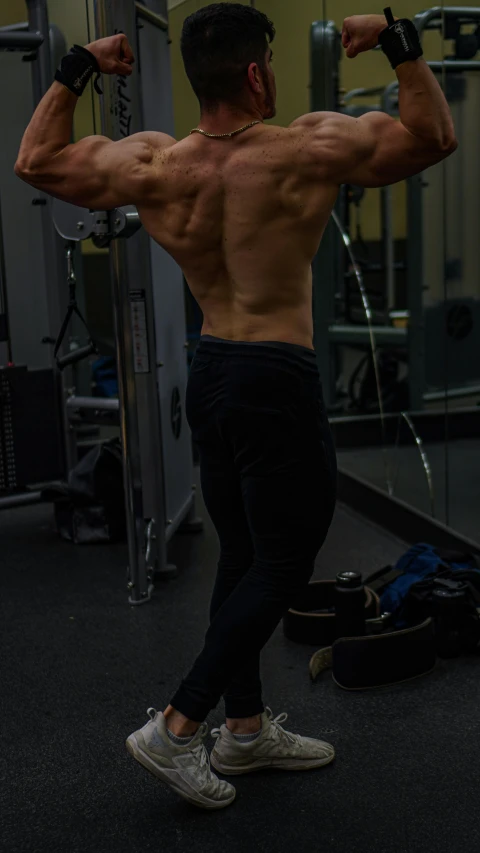 a shirtless man doing a chest press with barbells