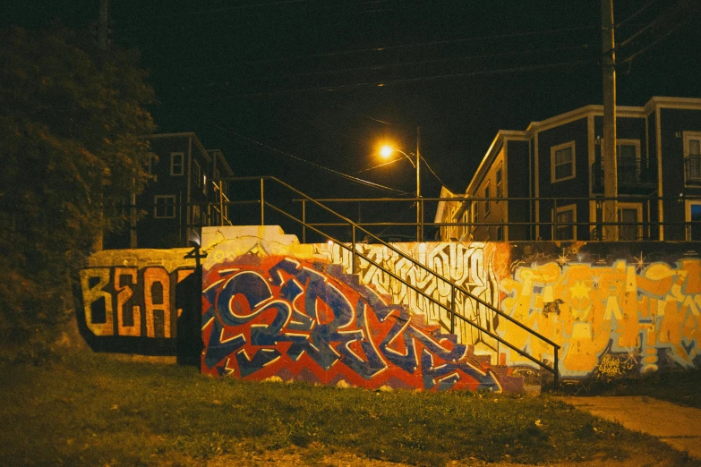 a man riding a skateboard in front of a wall with graffiti