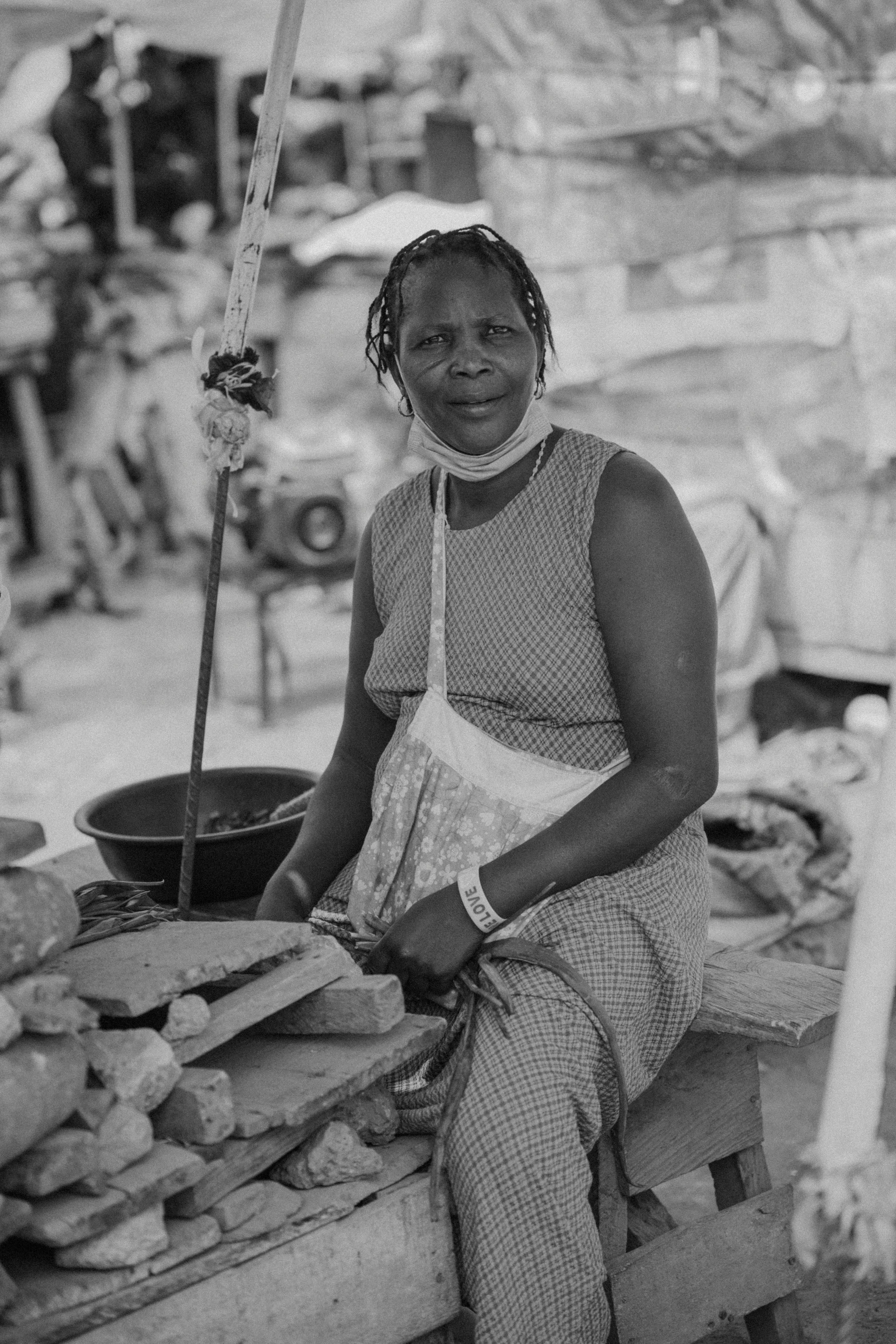 a woman smiles as she sits outside her home