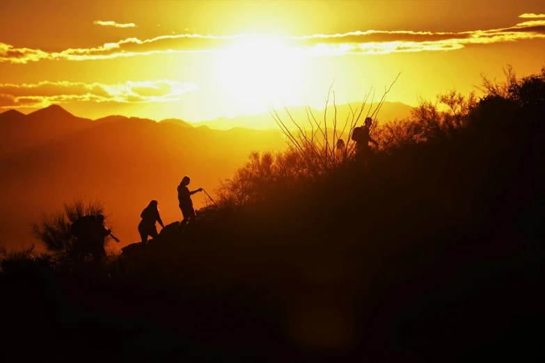 two people walking uphill at sunset or dawn