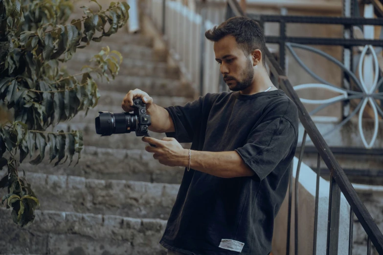 a man holding a camera next to a stair case