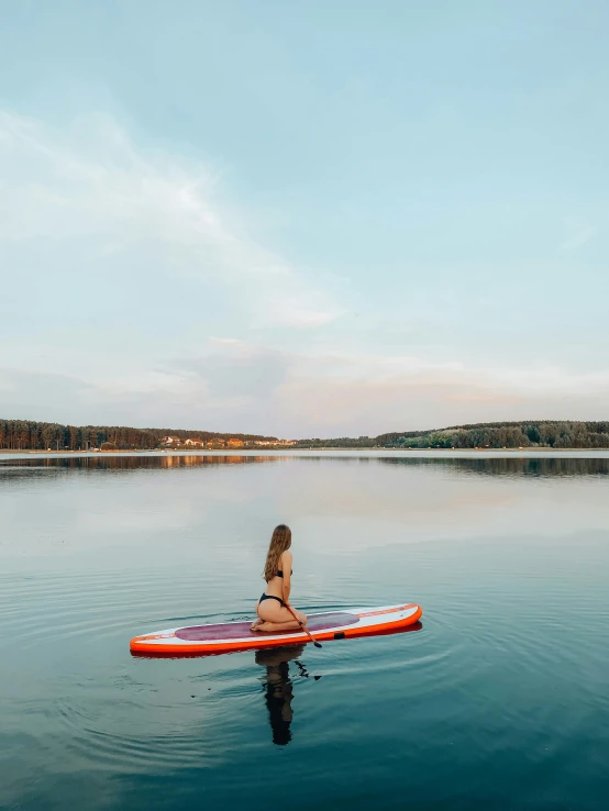 a woman sitting on top of a surfboard in the water