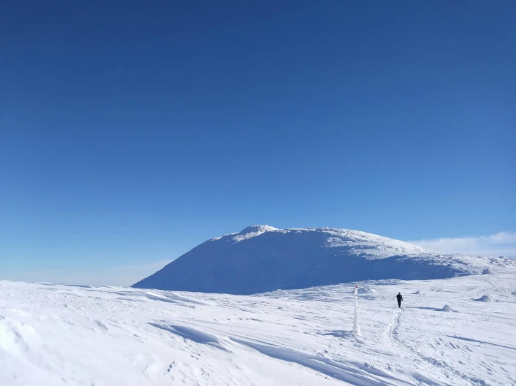 a person on skis in the snow next to a mountain