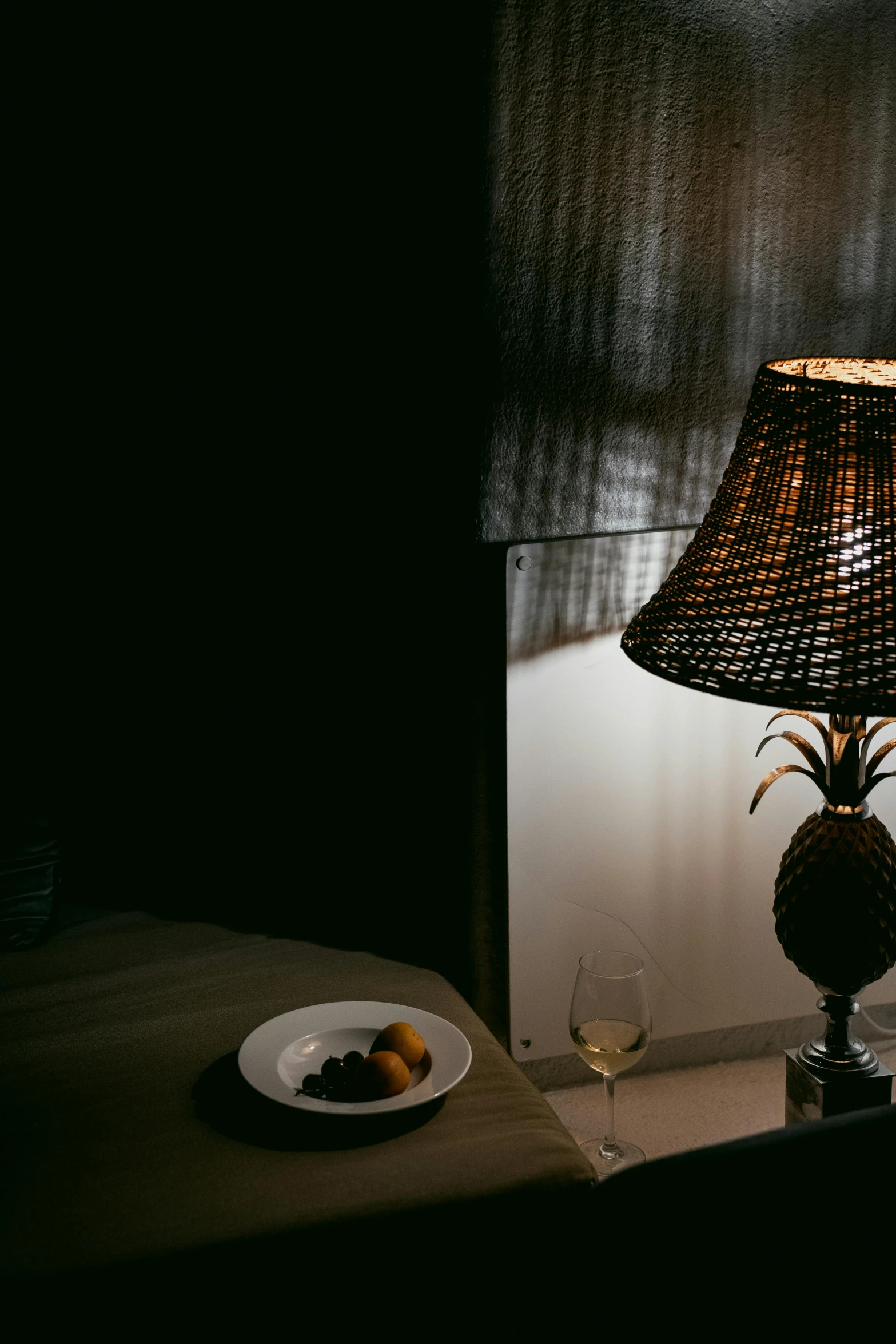 a bowl of fruit and a glass on a table