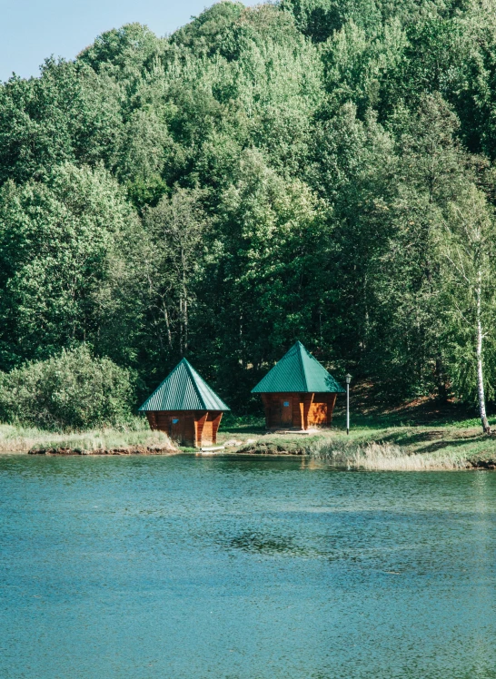 an image of two pavilions sitting next to water