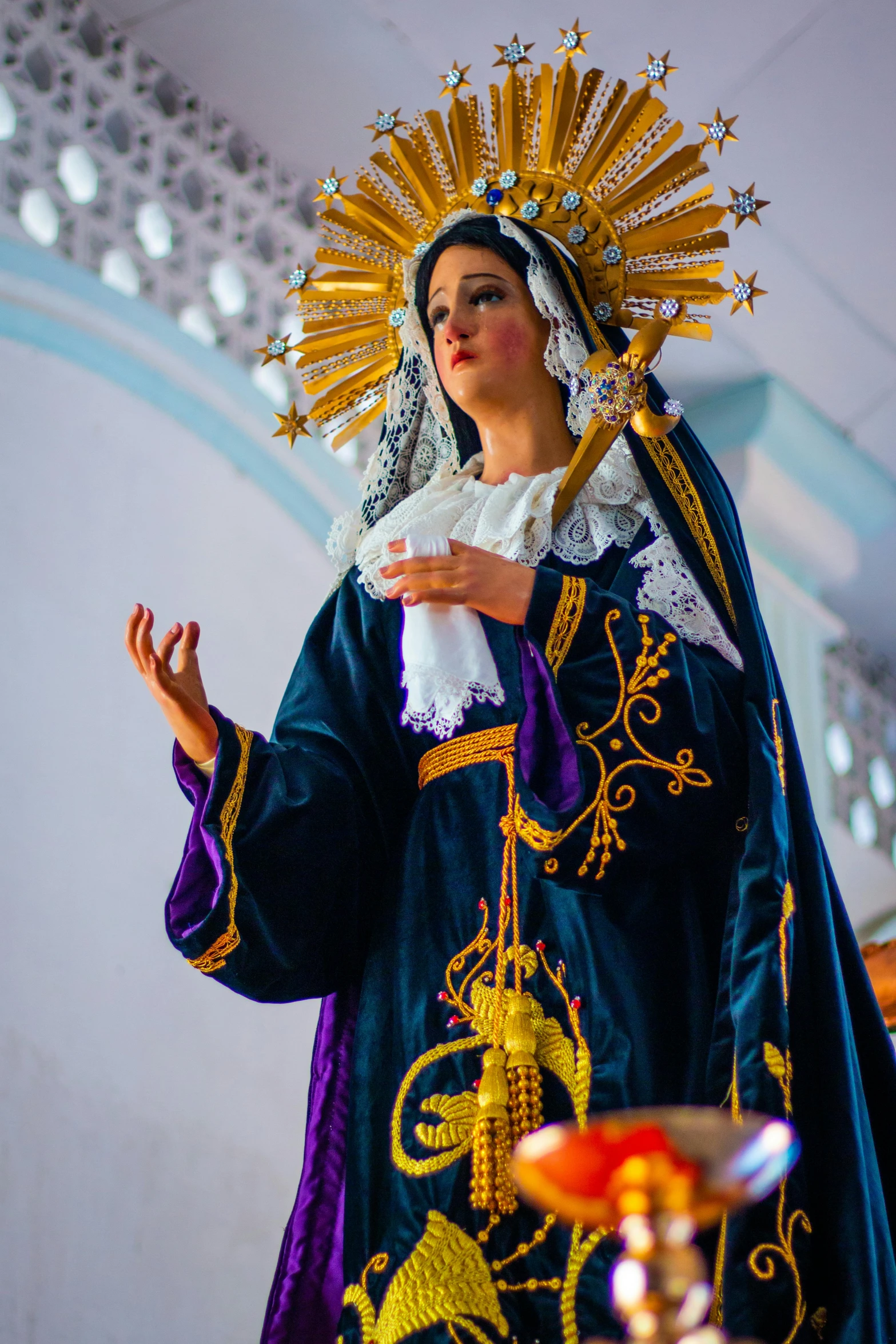 a woman dressed in an elaborate robe with an umbrella and lights around her