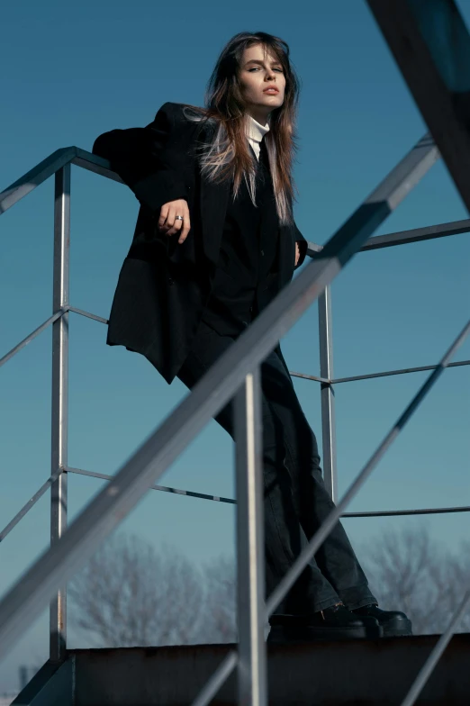 the woman is standing on the railing beside a metal railing