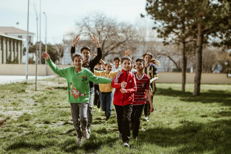 people running in a park with their arms outstretched