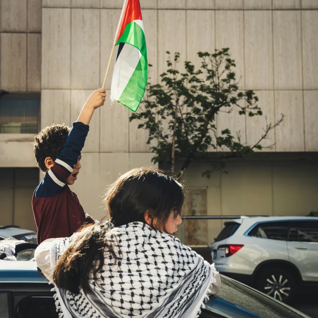 people at an intersection standing near a building