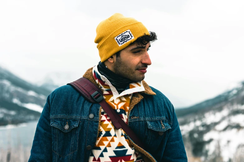 a man wearing a yellow and orange colored hat