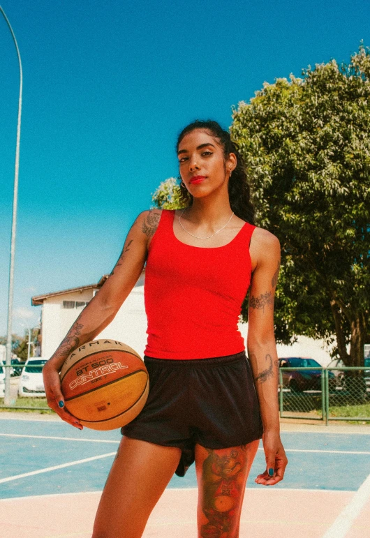 a woman is standing holding a basketball on a court