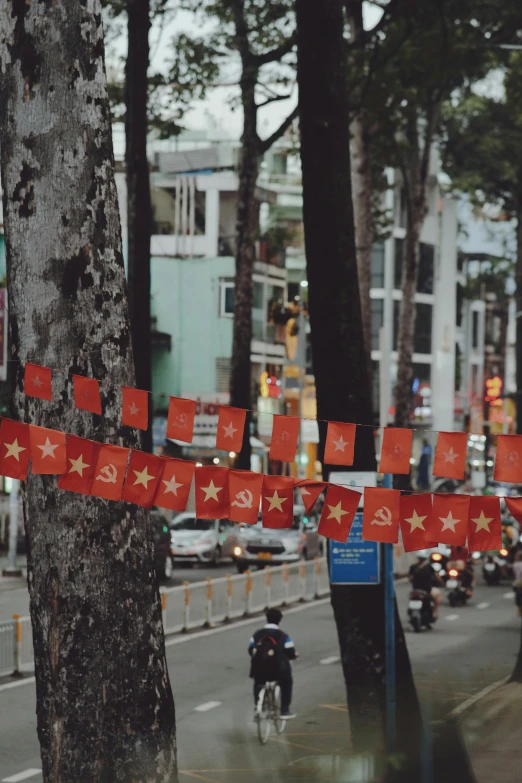 this is a city street with flags hanging on the sidewalk