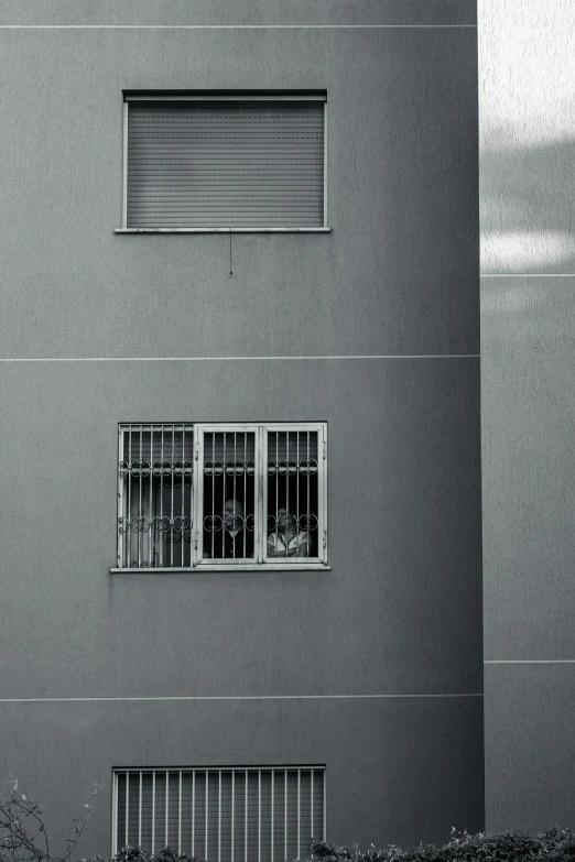 an empty window and bars on a dark grey building