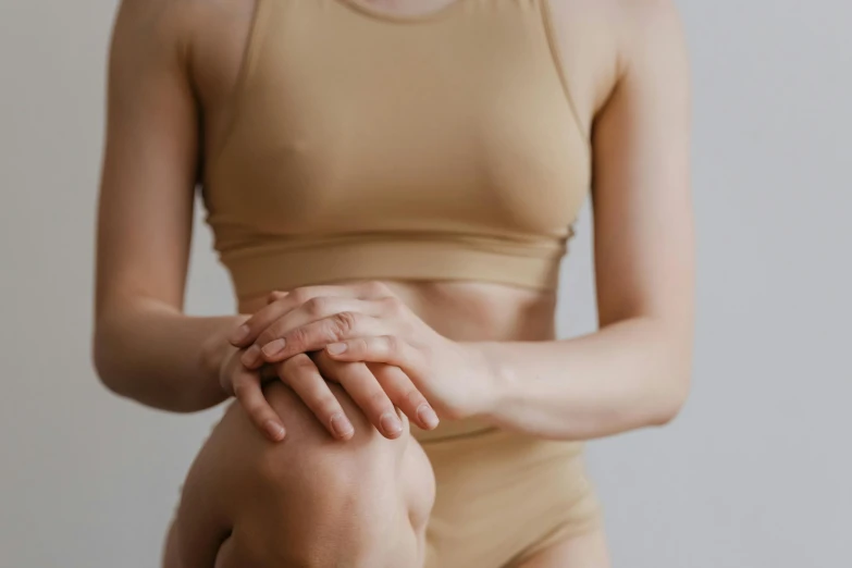 a young woman in tan is holding her hands together