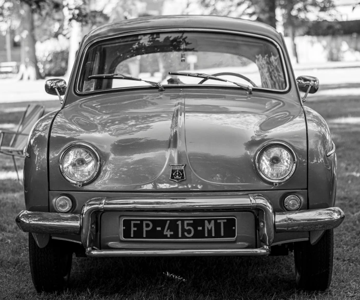 the front end of a classic car parked on grass