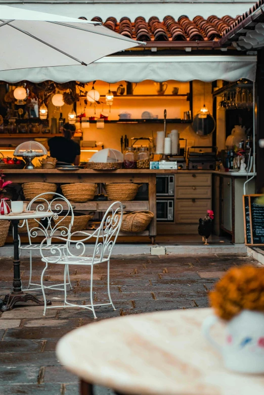 a cafe table, chairs and an umbrella on the patio