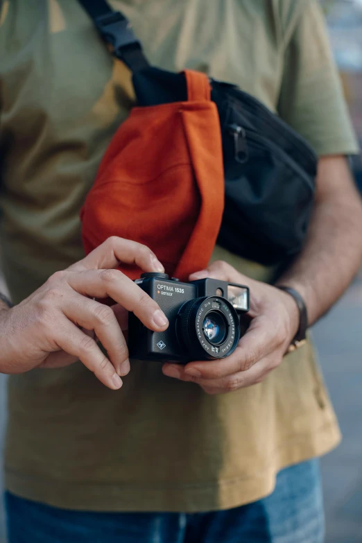 man holding up his camera outside on a sunny day