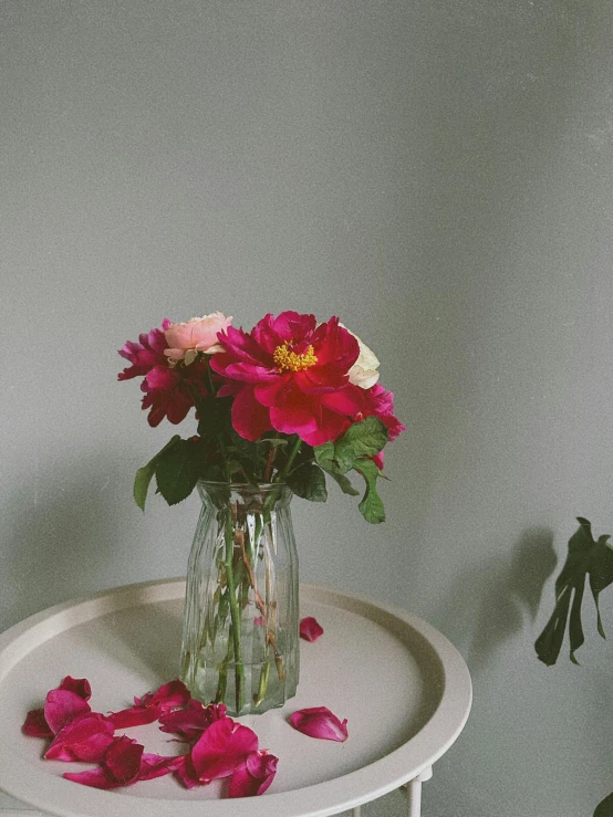 a vase full of red flowers and petals