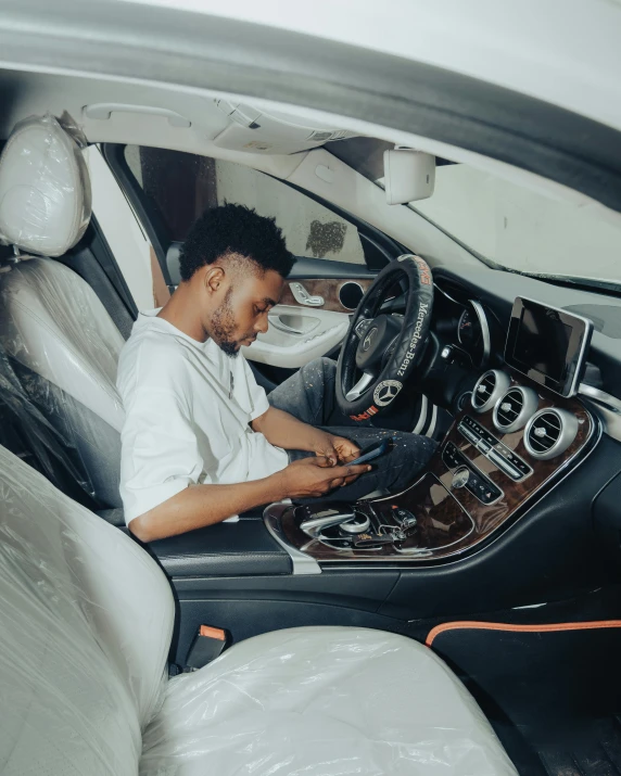 a man at a wheel of a car sitting inside