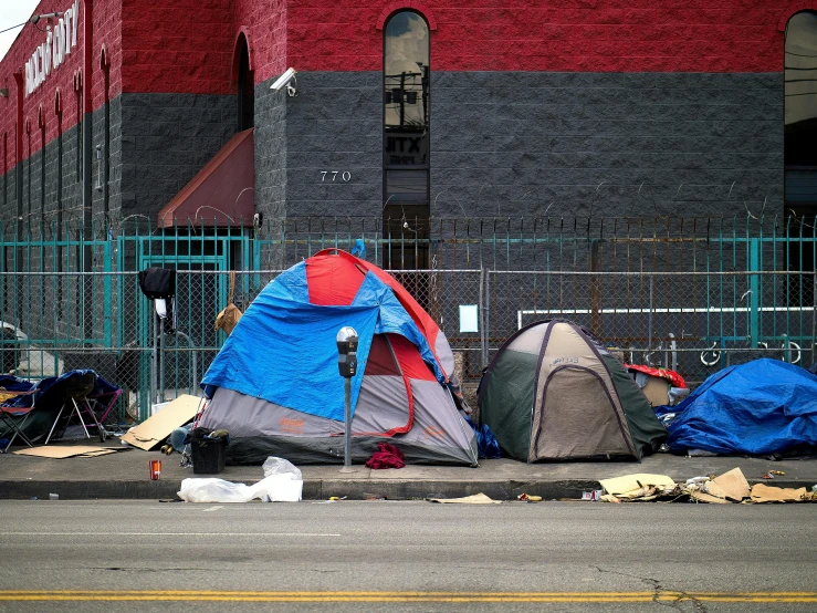 a bunch of tents in the street with blue tarps