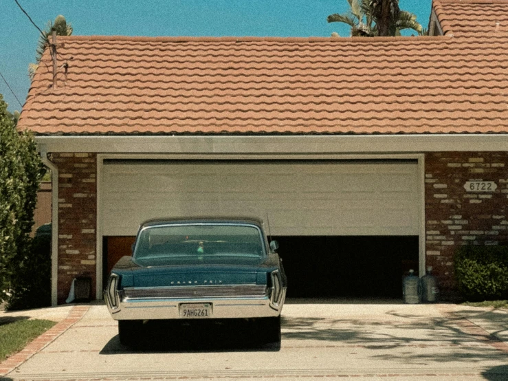 an old car in front of a garage