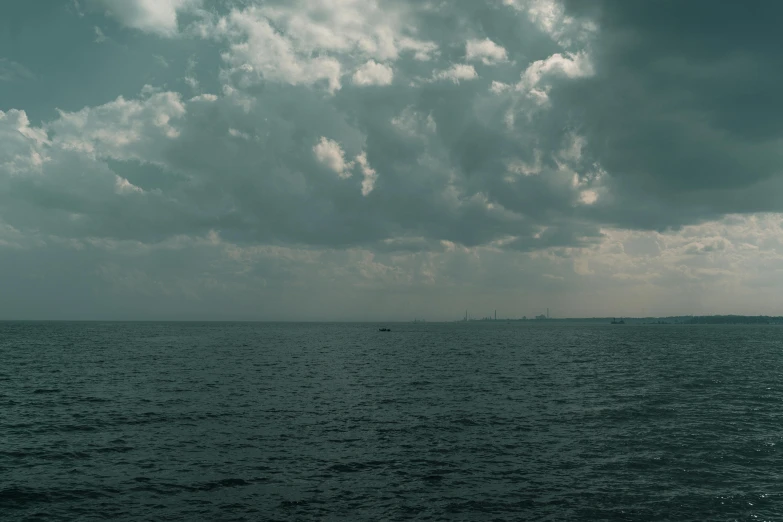 a large body of water with a small boat in the distance