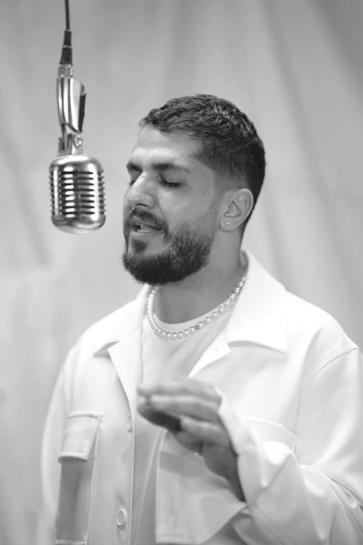 a man with a beard is listening into a microphone