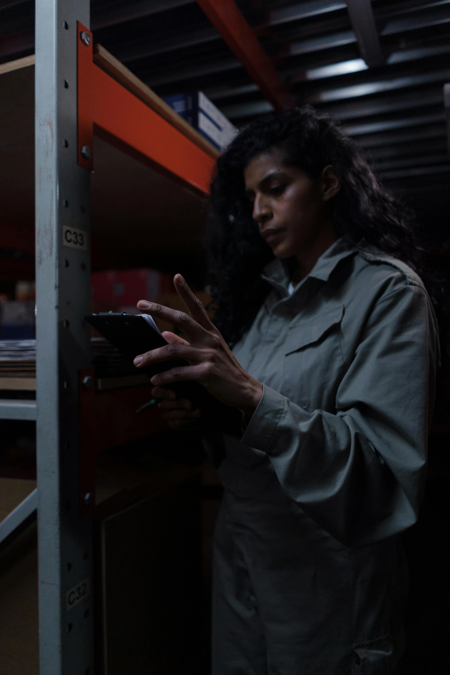 a woman stands by a shelf holding her cell phone