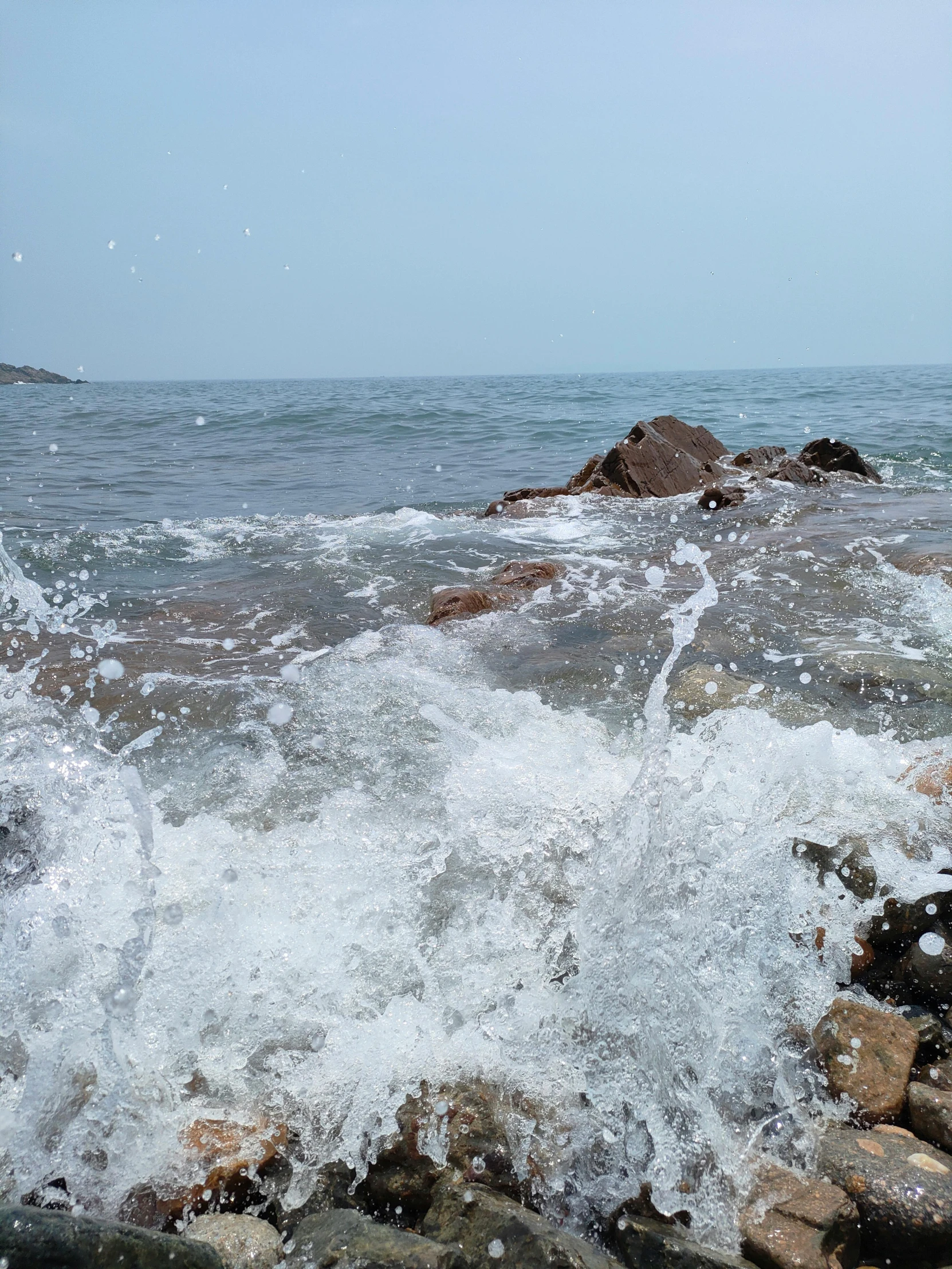 a person standing on rocks by the water