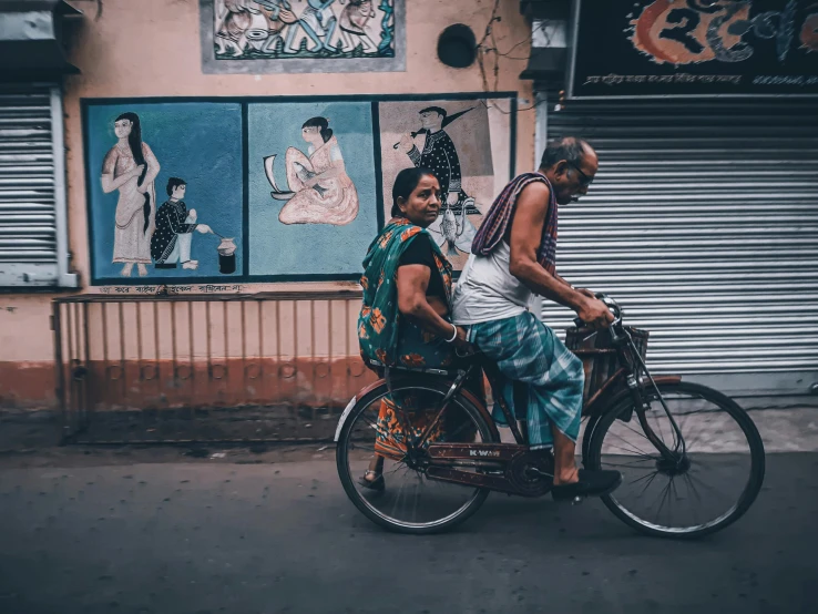 two people on a motor bike in front of a building