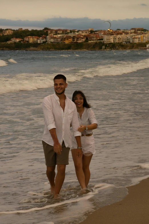 a couple is standing in the surf at the beach