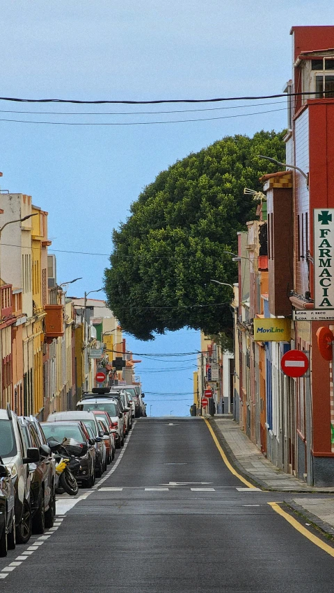 a view of a street with many buildings and cars parked on the side of it