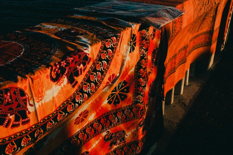 an orange table covered in some art and a chair