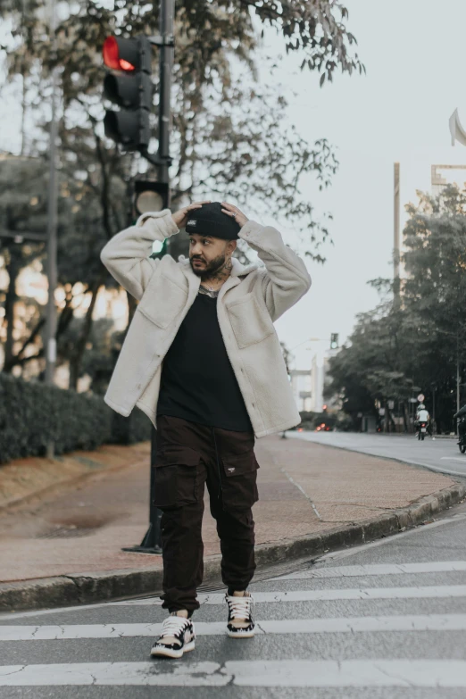 man standing at intersection in urban setting on cold day