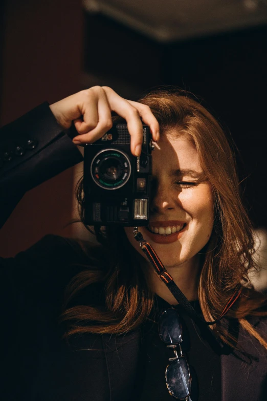 a woman in a suit is taking pictures with a camera