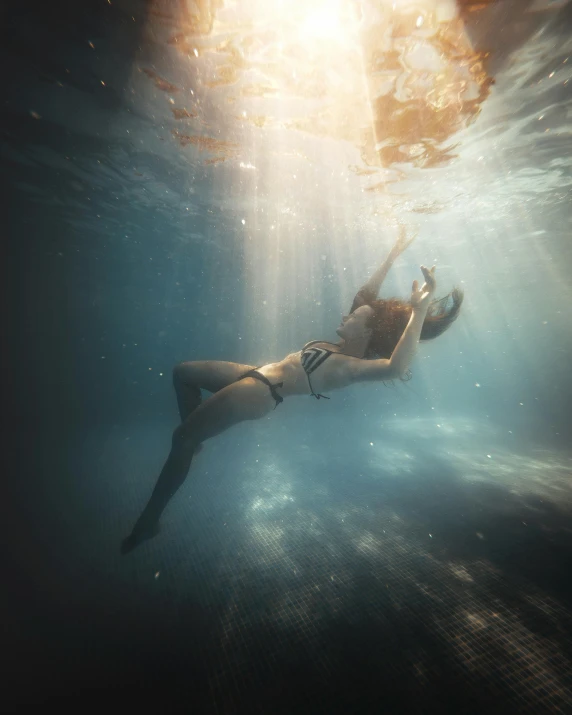 a woman swimming underwater in the water