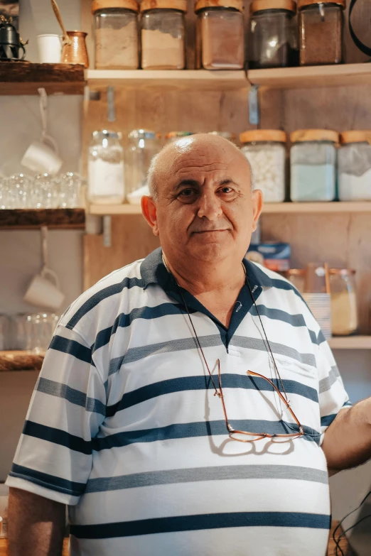 a man in a white and blue shirt is standing with glasses on