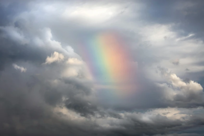 this po features heavy clouds as a rainbow lights up the sky