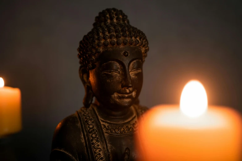 a candle lit inside of a buddha statue