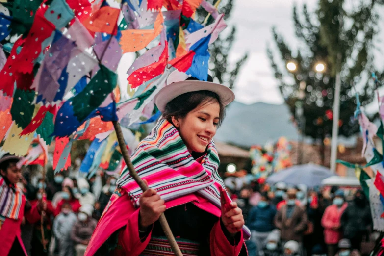 an oriental woman carrying some colorful flags while looking at the camera