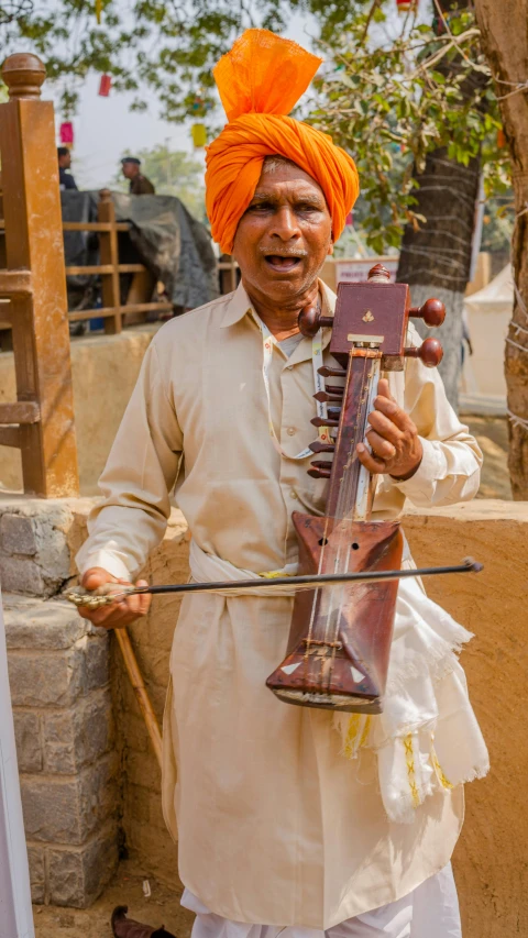 an elderly man is holding up a musical instrument