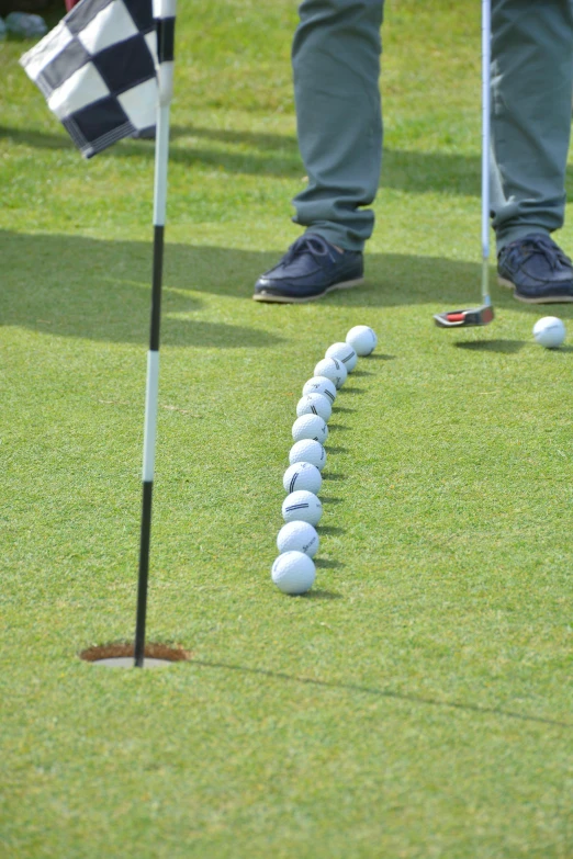 a group of golf balls arranged in a line with a flag next to them