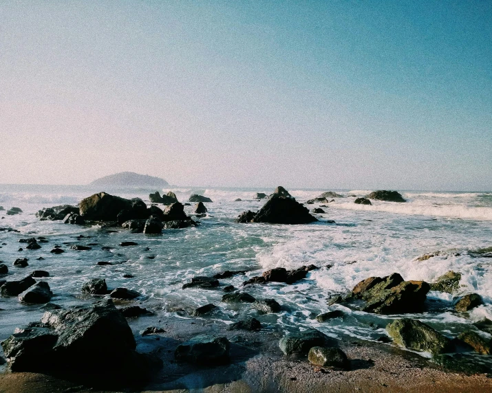 rocks in the water and some snow on it