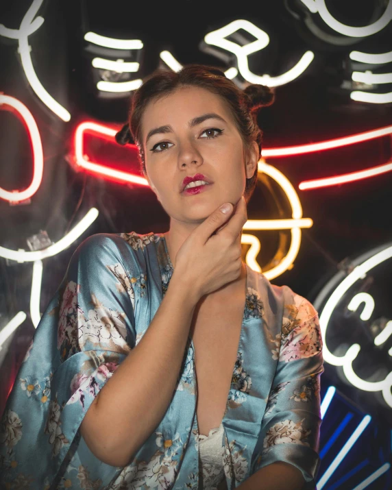 a woman wearing blue clothes is posing in front of bright signs